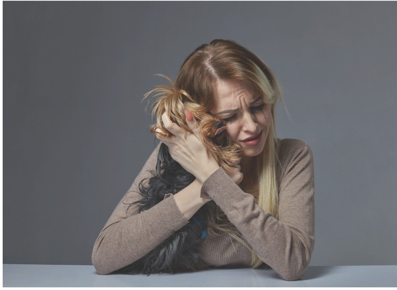 Une femme rassure son chien avant une séparation